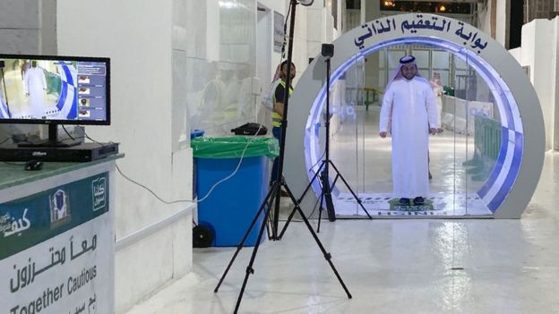 Un hombre pasa por una puerta de esterilización en la entrada de una mezquita en Arabia Saudita.