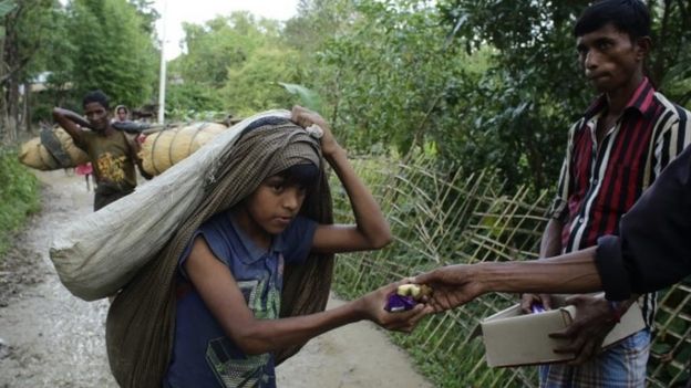 Rohingya refugees receive bread and bananas from local people as they arrive in Tuangiri, Teknaf, Bangladesh (12 September 2017)