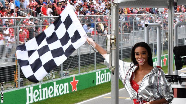 Winnie Harlow waves the chequered flag