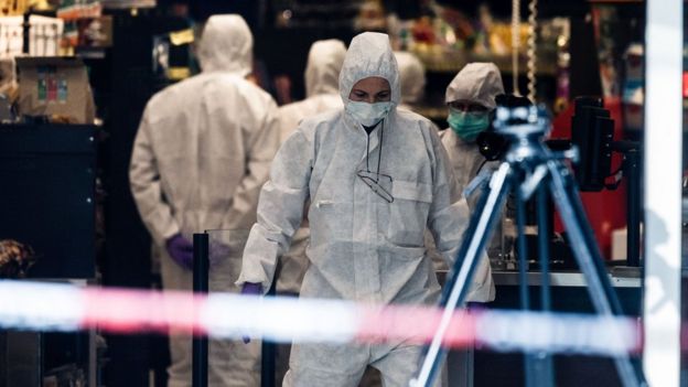 Police investigators gather evidence at a supermarket in the northern German city of Hamburg, where a man killed one person and wounded several others in a knife attack, 28 July 2017