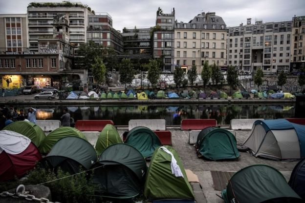 مهاجرون يجلسون بجانب خيامهم في معسكر مؤقت على طول قناة سان مارتن في باريس في 25 مايو2018