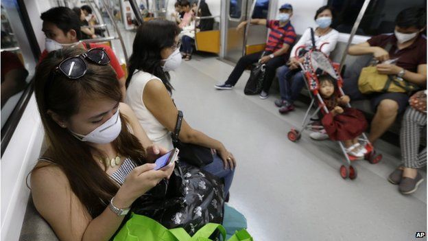 Philippines tourists wear masks as a precaution against the MERS, Middle East Respiratory Syndrome, virus on a subway train in Seoul, South Korea, Sunday, 7 June 2015.