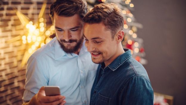 pareja gay usando celular