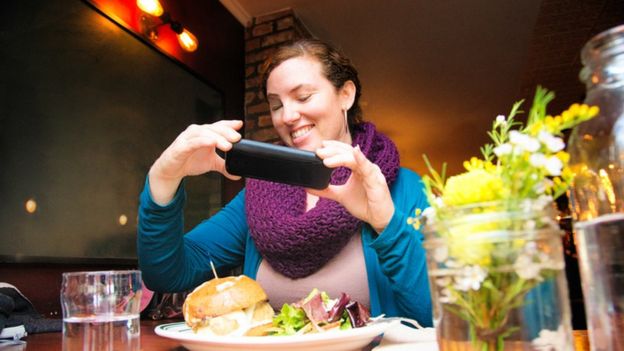 Mujer fotografiando su comida