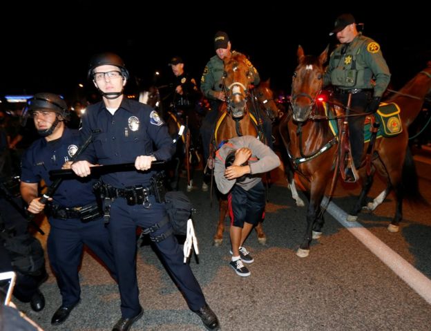 Police hold back Trump opponents in Costa Mesa, California, 28 April