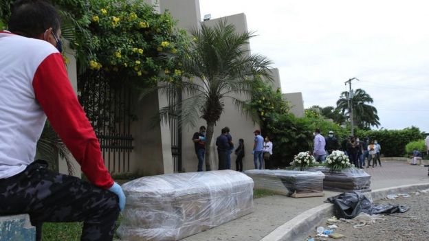 Relatives of deceased people queue outside a cemetery in Guayaquil, April 2020