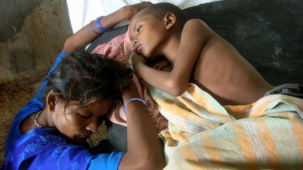 Madre junto a su hijo enfermo de encefalitis japonesa en un hospital de India.