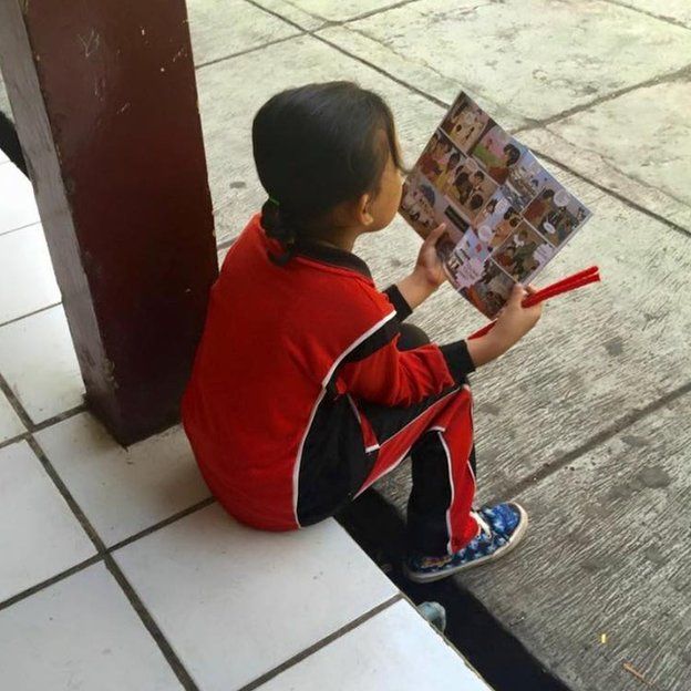 Девушка из Индонезии читает комикс, предупреждающий о торговле людьми