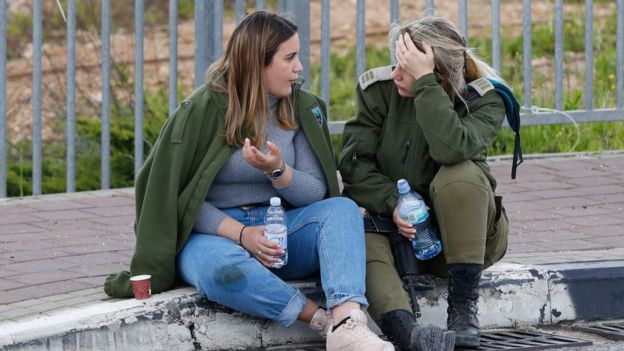 An Israeli soldier speaks to a woman at the scene of a deadly attack near the Jewish settlement of Ariel in the occupied West Bank (17 March 2019)