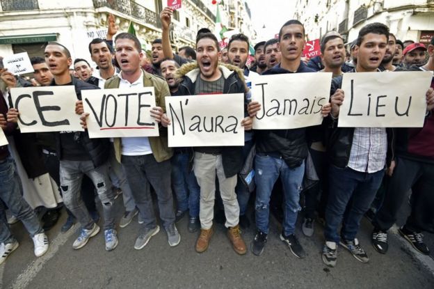 Algerian demonstrators on 6 December carry placards that read in French: "This vote will never happen".