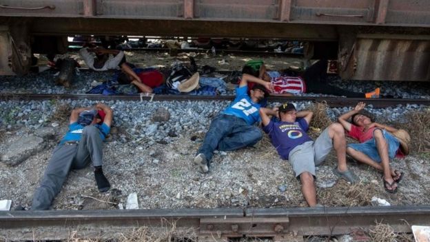 Migrants from the caravan rest on rail tracks in Arriaga, Mexico. Photo: 26 October 2018