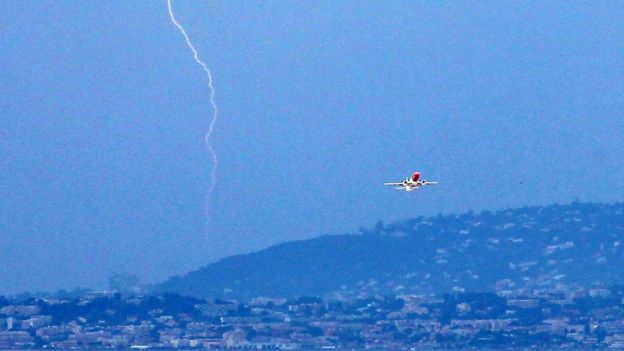 A plane takes off from Nice airport in France as lightning strikes, 5 June 2011