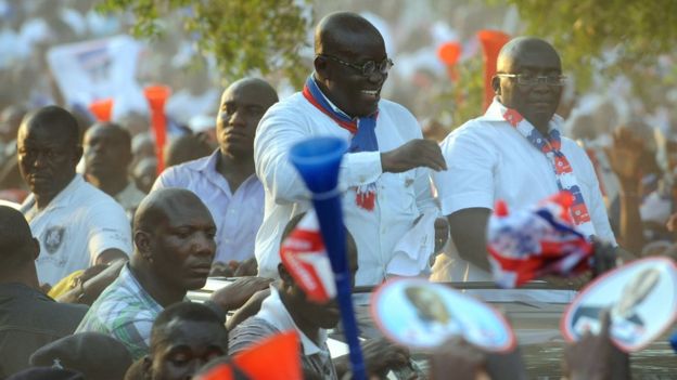 Nana Akufo-Addo greets party supporters from an open-top vehicle.