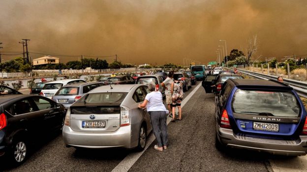 Cars are blocked at the closed National Road during a wildfire in Kineta, near Athens, on July 23, 2018
