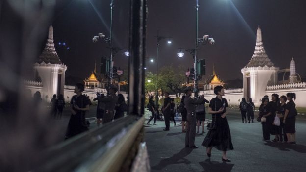 Mourners wearing black walk outside the Temple of the Emerald Buddha on October 27 2017