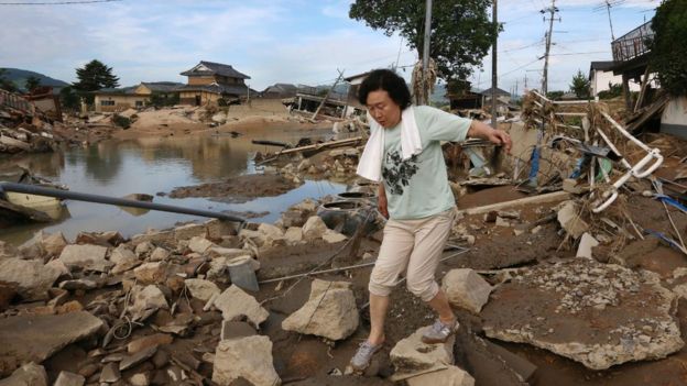 A resident walks across scattered debris in a flood hit area in Kurashiki, Okayama prefecture on July 9, 2018.