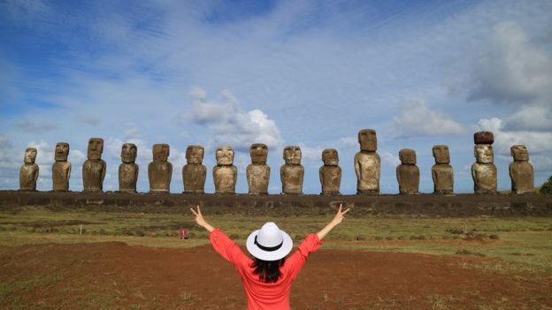 Turista frente a estatuas de moai.