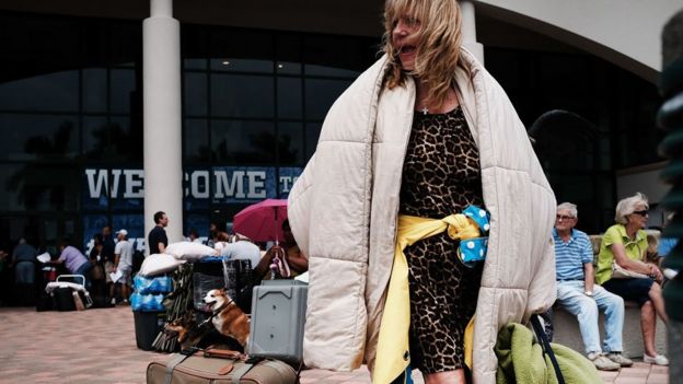 Une femme arrive avec ses bagages dans un centre d'accueil à Alico Arena en Floride