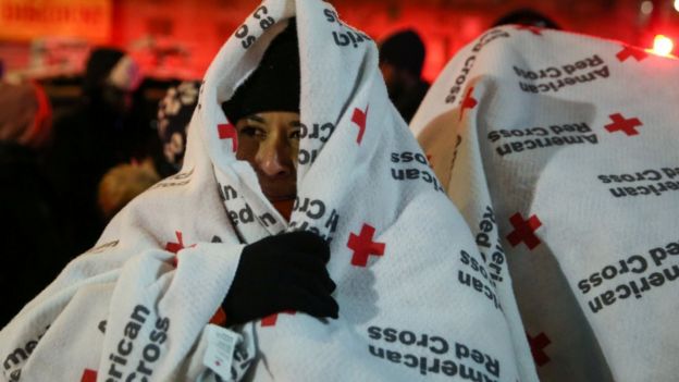 Evacuees wear blankets as they stand after a fire at an apartment building in Bronx, New York, U.S., December 28, 2017.