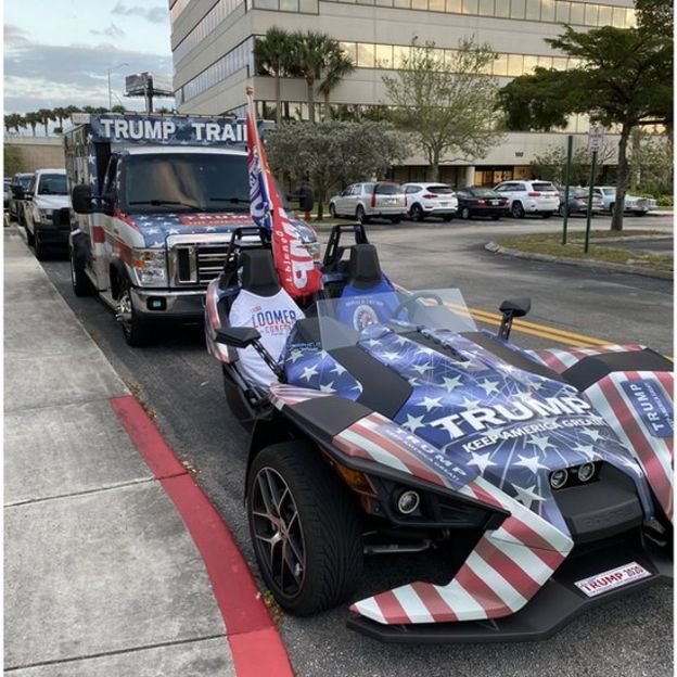 Trump logo-emblazoned car outside venue