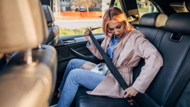 Mujer poniéndose el cinturón de seguridad