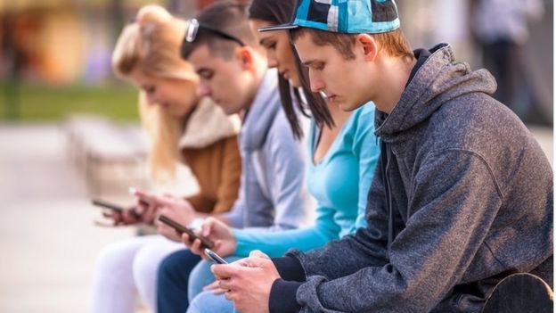 Unos jóvenes mirando su teléfono celular