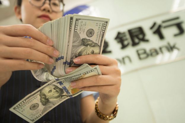 Una cajera de un banco chino contando dÃ³lares