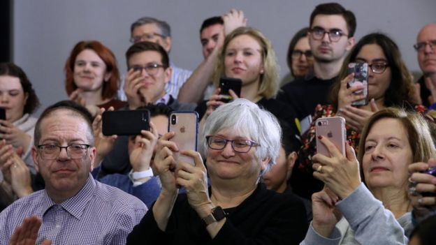 Un grupo de personas asisten a un acto de campaña de la senadora Elizabeth Warren.