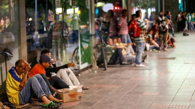 Venezolanos sentados en el suelo