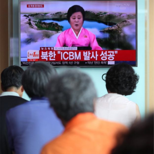 La gente se agolpa en Tokio para ver cómo Ri Chun-hee, la inconfundible presentadora de noticias de Corea del Norte, anuncia el lanzamiento de un nuevo misil el 4 de julio de 2017.