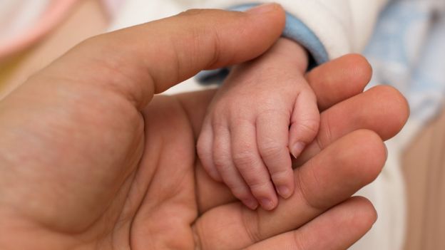 Mão de mãe e de bebê