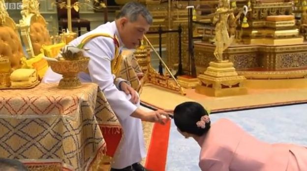 Raja meneteskan air suci pada Ratu Suthida saat mereka menikah di bulan Mei.