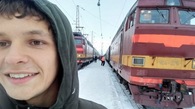 Elias Bohun standing outside trains in Siberia