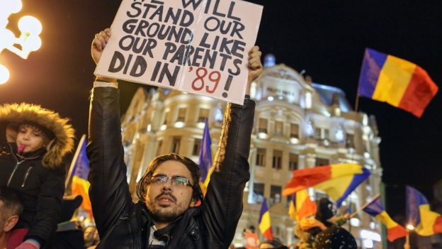 Un hombre con un cartel durante una protesta en Rumania