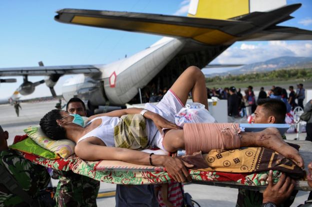 An injured man awaits evacuation at Palu airport, 30 September