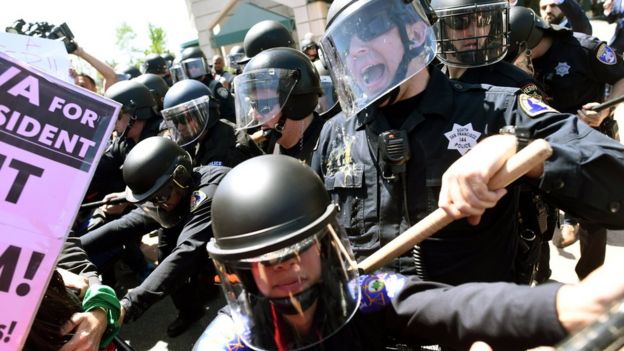 Police in riot gear hold back demonstrators against U.S. Republican presidential candidate Donald Trump outside the Hyatt hotel