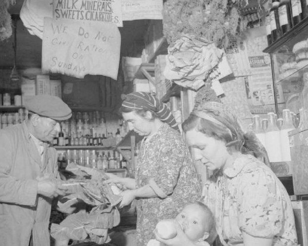 Mr and Mrs Thabeth's general store in the 1940s. Mrs Hassan feeding her baby son, Hamed. Also visible is the sigs above the counter which reads: "We do not give rations on Sundays."