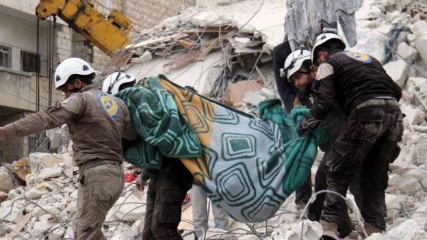 சிரியாவில் நடக்கும் போரில் பாதிக்கப்பட்ட நபரை தூக்கி செல்லும் வெயிட் ஹெல்மெட் என்ற சிரிய சிவில் பாதுகாப்பு தொண்டர்கள்