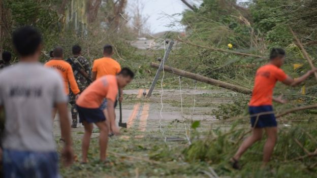 Workers clear roads after Typhoon Mangkhut made landfall