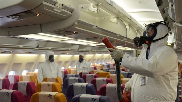 Funcionários aplicam solução antisséptica em avião na Tailândia, em 2015, como prevenção à síndrome respiratória Mers