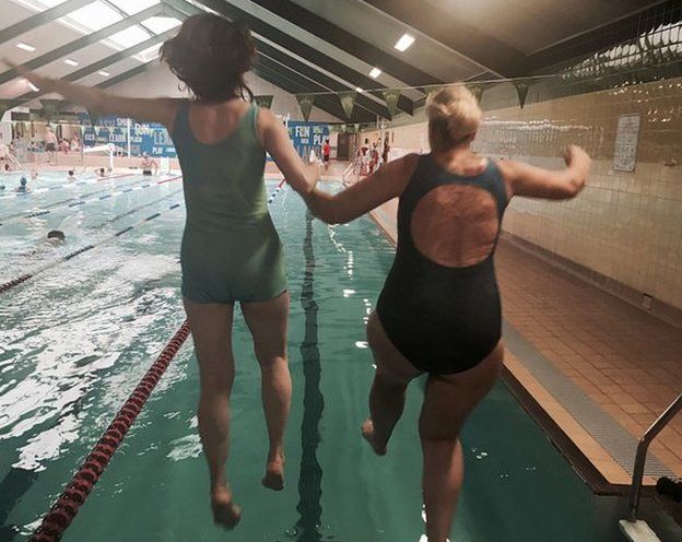 Sylvia Mac e uma garota pulam em uma piscina