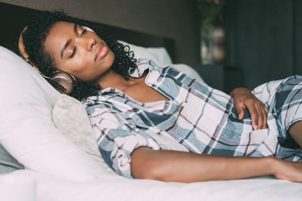 A woman who has fallen asleep listening to an audio book