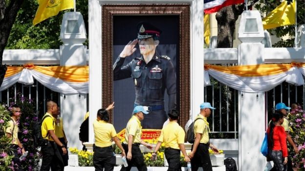 People walk in front of a portrait of Thailand's King Maha Vajiralongkorn during a rehearsal of his coronation procession which will take place next week in Bangkok, Thailand April 28, 2019.