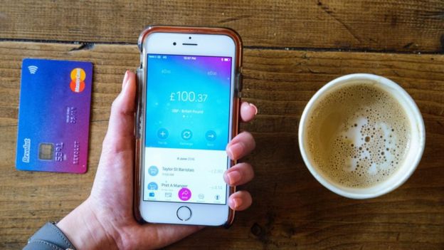 Revolut app, debit card and cup of coffee