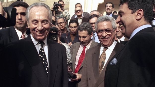 In this Wednesday, Dec. 29, 1993, file photo, Israeli Foreign Minister Shimon Peres is all smiles along with PLO negotiator Mahmoud Abbas and Egyptian Foreign Minister Amr Moussa
