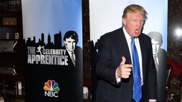 Trump con un afiche de The Celebrity Apprentice
