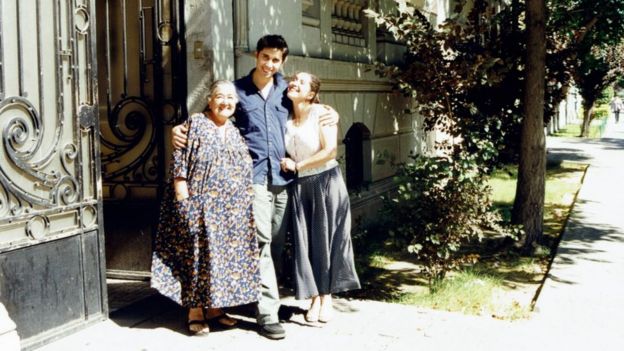 Luis Recabarren na calçada de um imóvel abraçado com a avó Ana González e a tia Patricia