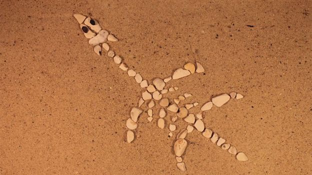 ictiosaurio hecho con piedras sobre la arena