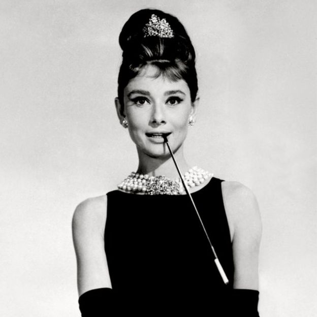 Audrey Hepburn in black dress, pearl necklace, beehive hair and long black gloves