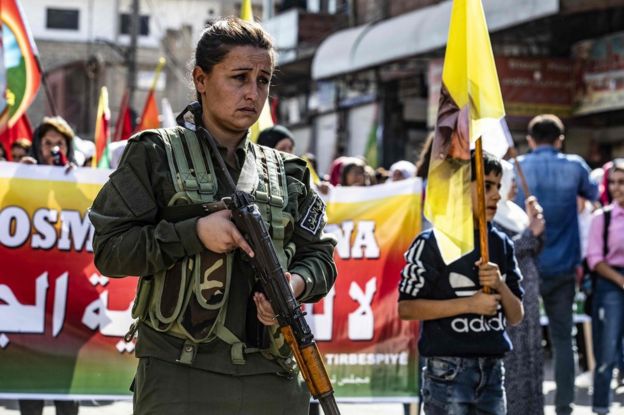 A member of the Kurdish Internal Security Police Force of Asayesh stands guard as Syrian Kurds demonstrate against Turkish threats to launch a military operation on their region, in the town of Al-Qahtaniyah, in north-eastern Syrian Al-Hasakah Governorate on October 7, 2019.